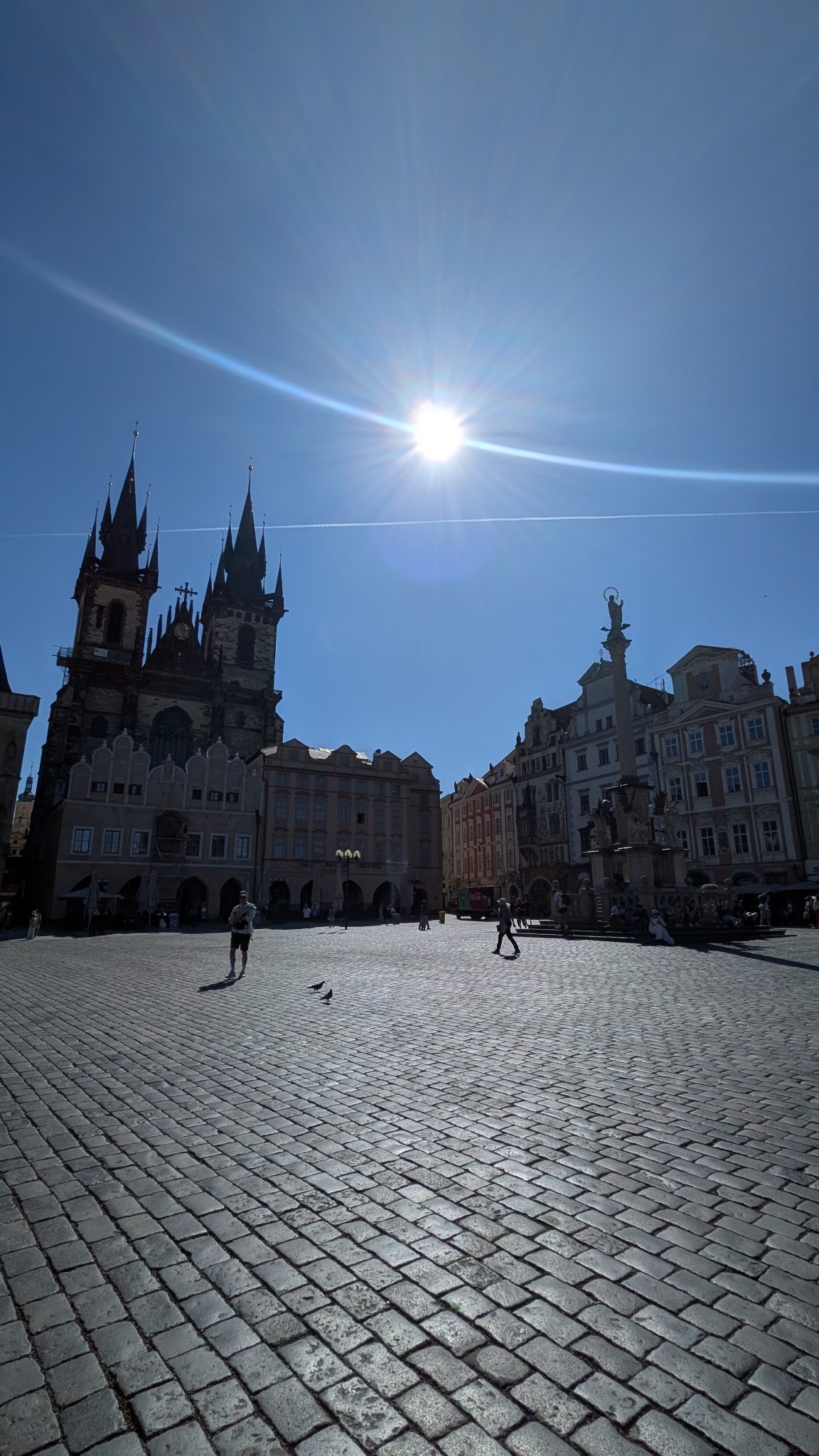 Old Town Square in Prague with Gothic towers, blue sky and cobbled streets